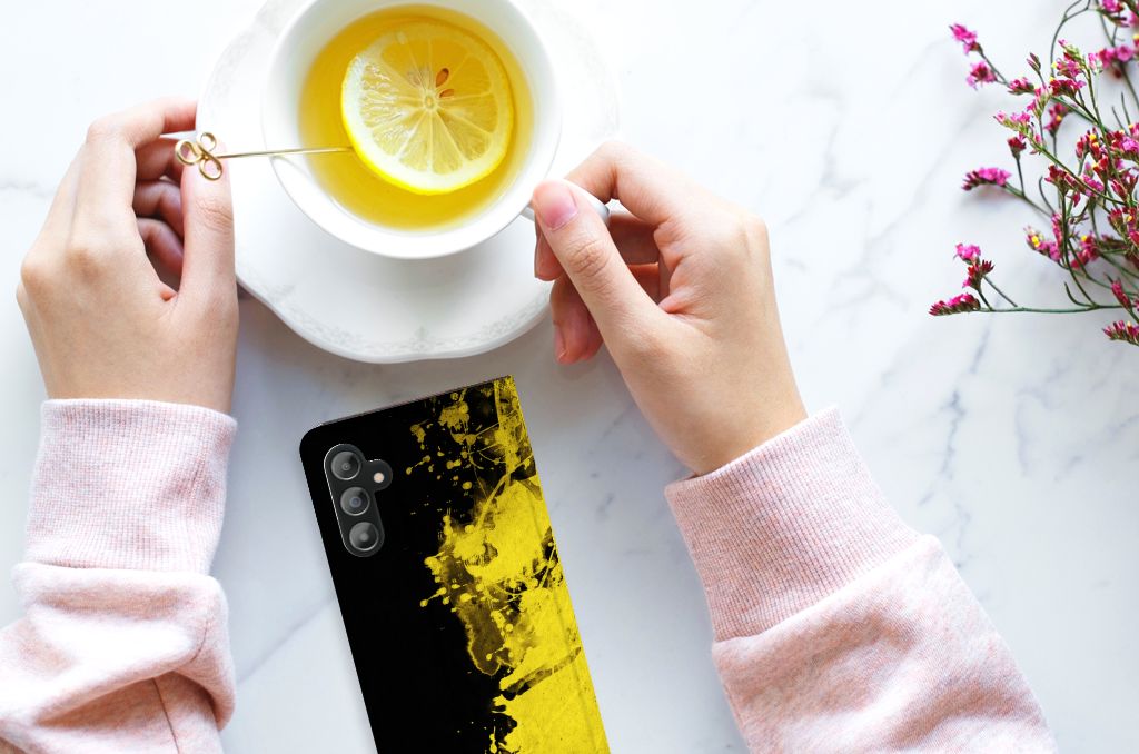Samsung Galaxy A14 4G Standcase België met Belgische kleuren rustend op een marmeren tafel met een kopje thee.