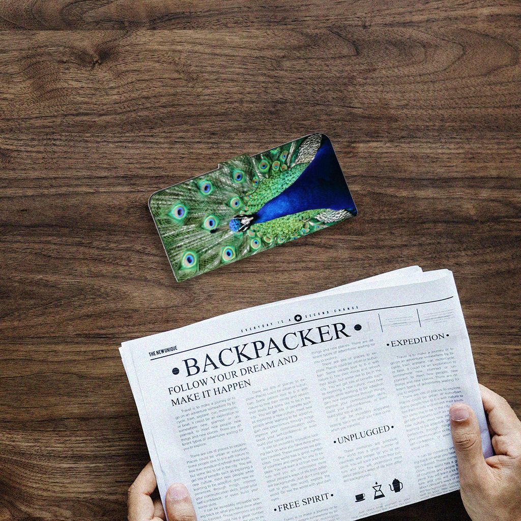 Samsung Galaxy A14 4G Telefoonhoesje met Pasjes Pauw op een tafel met een krant ernaast.