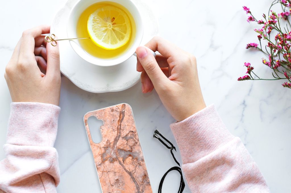 Samsung Galaxy A14 5G Anti-Shock Hoesje Marmer Oranje met een kopje thee en schijfje citroen op tafel.