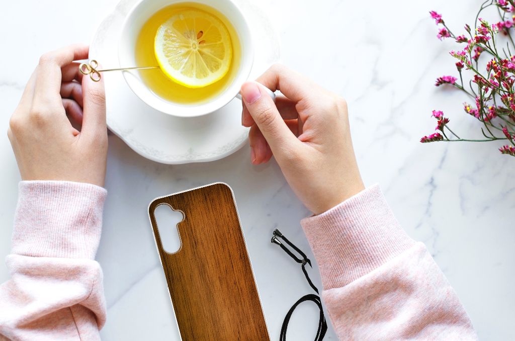 Samsung Galaxy A14 5G Stevig Telefoonhoesje Donker Hout met een kopje thee en citroen.