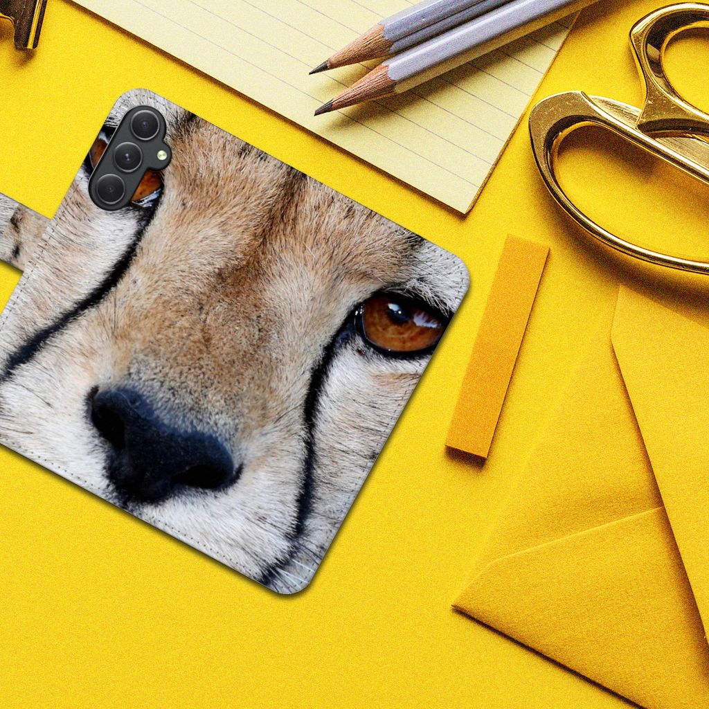 Samsung Galaxy A24 4G Telefoonhoesje met Pasjes Cheetah close-up op een gele achtergrond met kantoorbenodigdheden