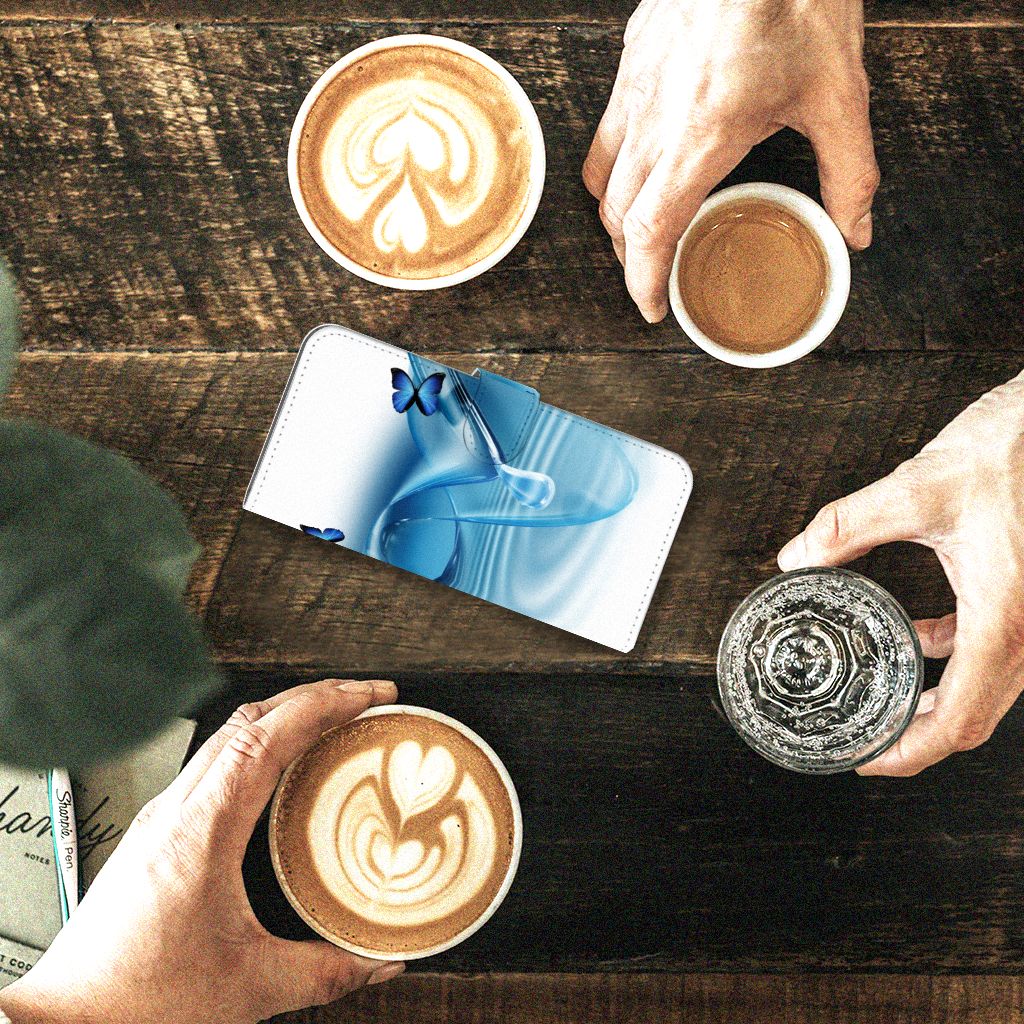 Samsung Galaxy A24 4G Telefoonhoesje met Pasjes Vlinders design blauwe vlinders aanzicht op tafel met koffie