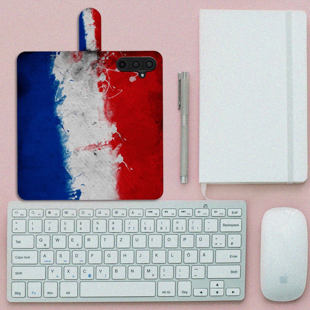 Samsung Galaxy M54 Bookstyle Case Nederland met artistiek ontwerp van de Nederlandse vlag op bureau met toetsenbord en notitieboek.