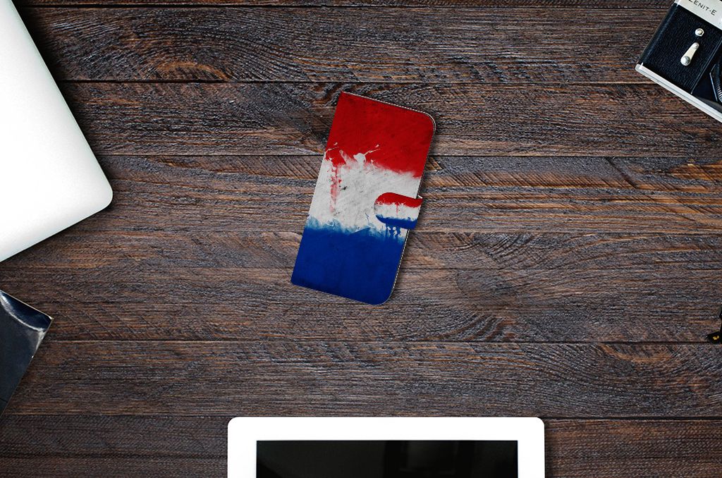 Samsung Galaxy S23 FE Bookstyle Case Nederland met artistiek ontwerp van de Nederlandse vlag op een houten tafel.
