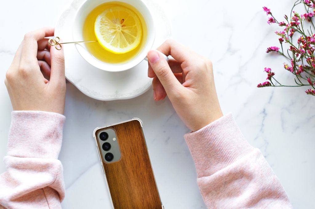 Samsung Galaxy S24 Stevig Telefoonhoesje Donker Hout bovenaanzicht met handen en kopje thee