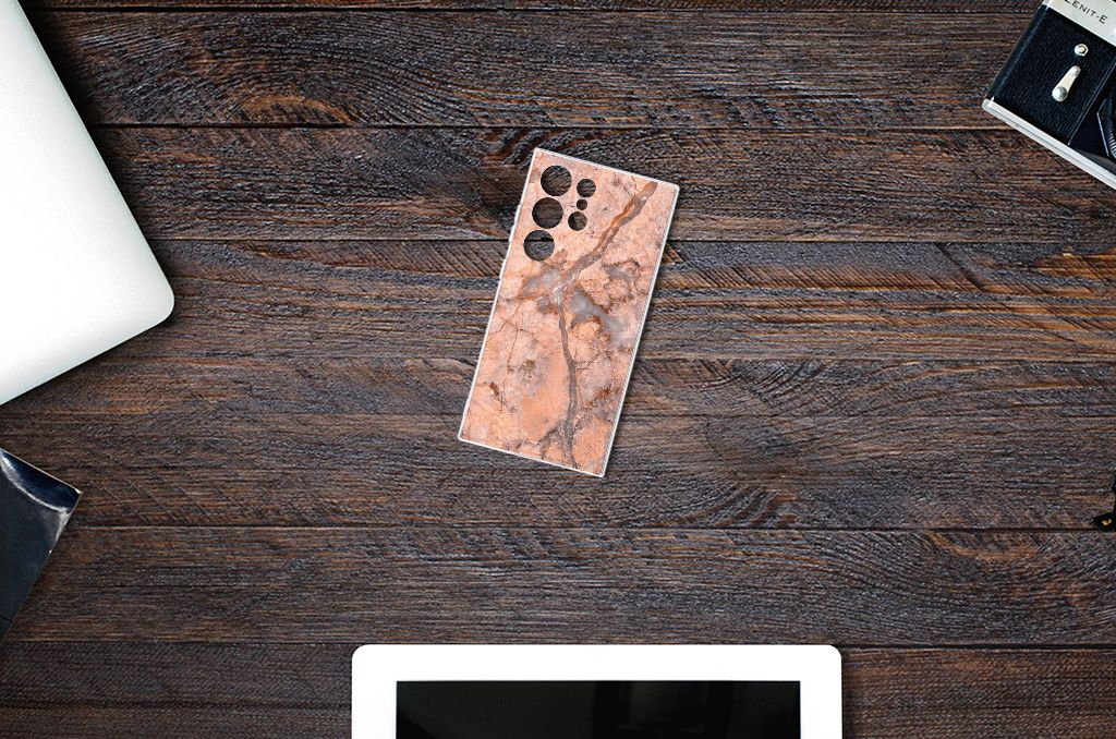 Samsung Galaxy S24 Ultra TPU Siliconen Hoesje Marmer Oranje op een houten bureau, ideaal voor bescherming en uitstraling.