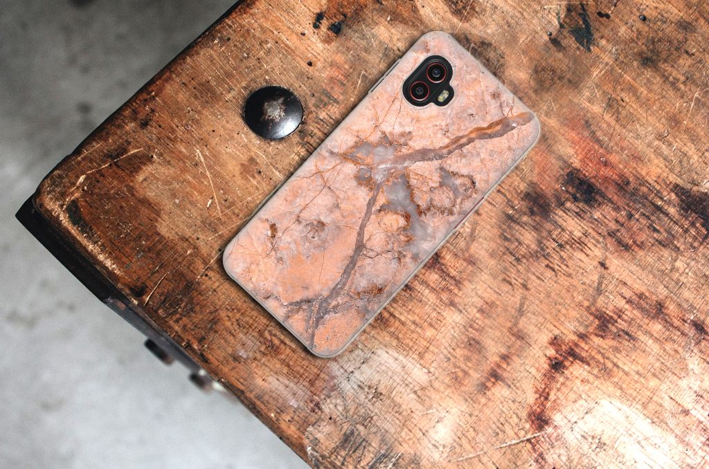 Samsung Galaxy Xcover 6 Pro TPU Siliconen Hoesje Marmer Oranje achterkant op houten tafel