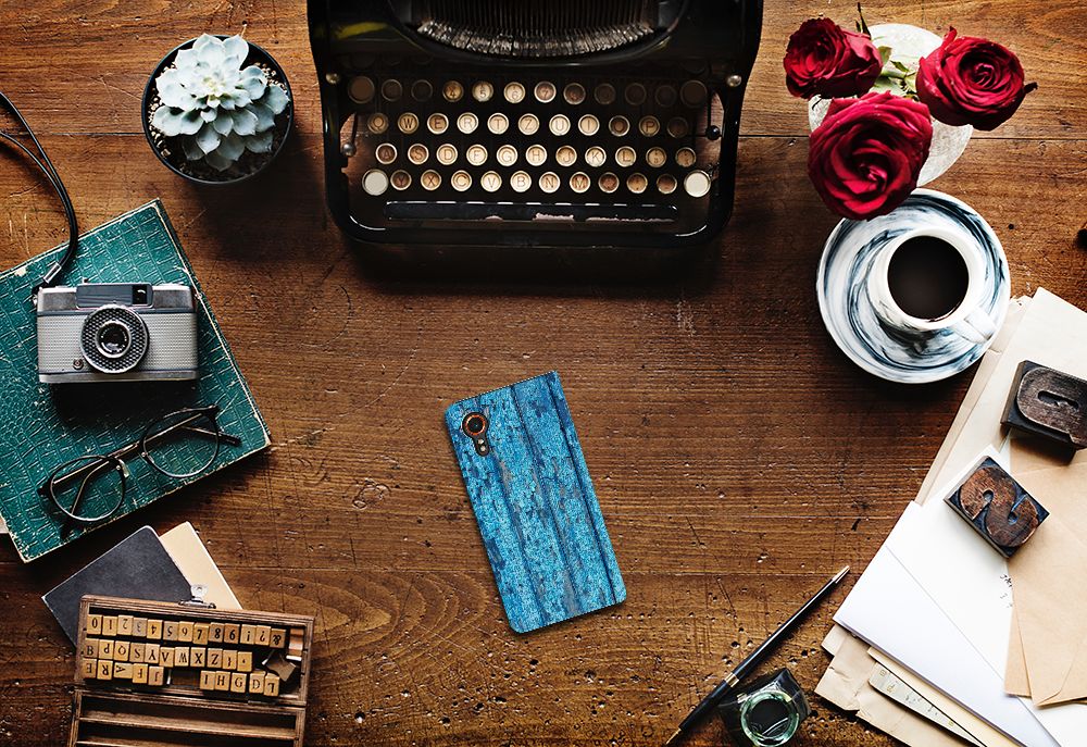 Samsung Galaxy Xcover 7 Book Wallet Case Wood Blue op een bureau met vintage accessoires voor gebruiksgemak en uitstraling.