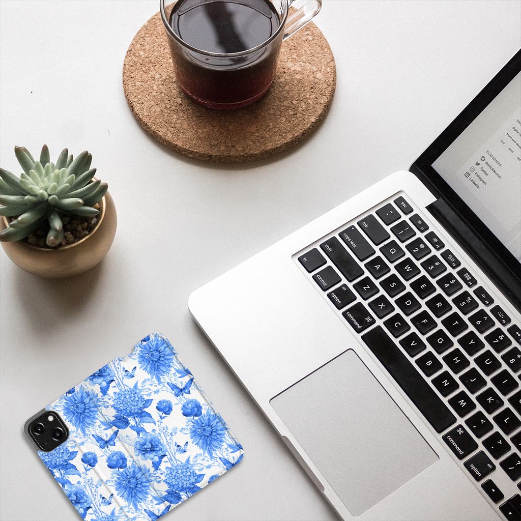 Smart Cover voor iPhone 13 Mini Flowers Blue met mooie blauwe bloemen op een bureau met laptop en planten.