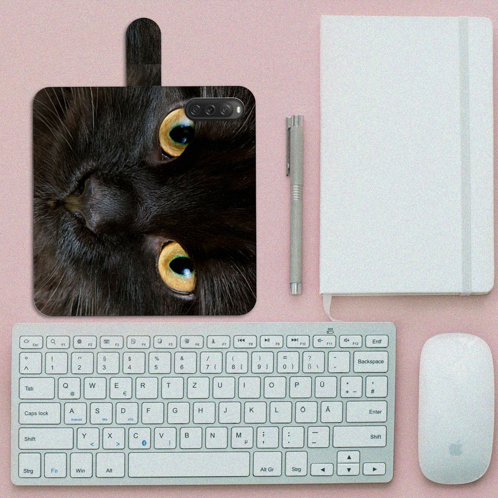 Sony Xperia 10 V Telefoonhoesje met Pasjes Zwarte Kat op een bureau met toetsenbord en muis, een opvallend ontwerp.