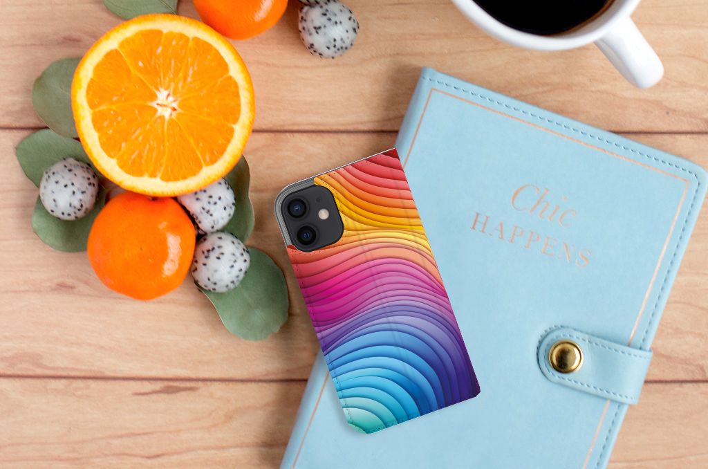 Stand Case voor iPhone 12 Mini Regenboog met kleurrijk golfdesign, naast een notitieboekje en fruit.