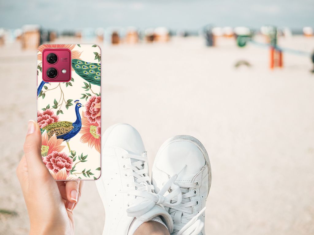 TPU Hoesje voor Motorola Moto G84 Pink Peacock op een strand met bloemen en pauwen. Perfect cadeau met gebruiksgemak!
