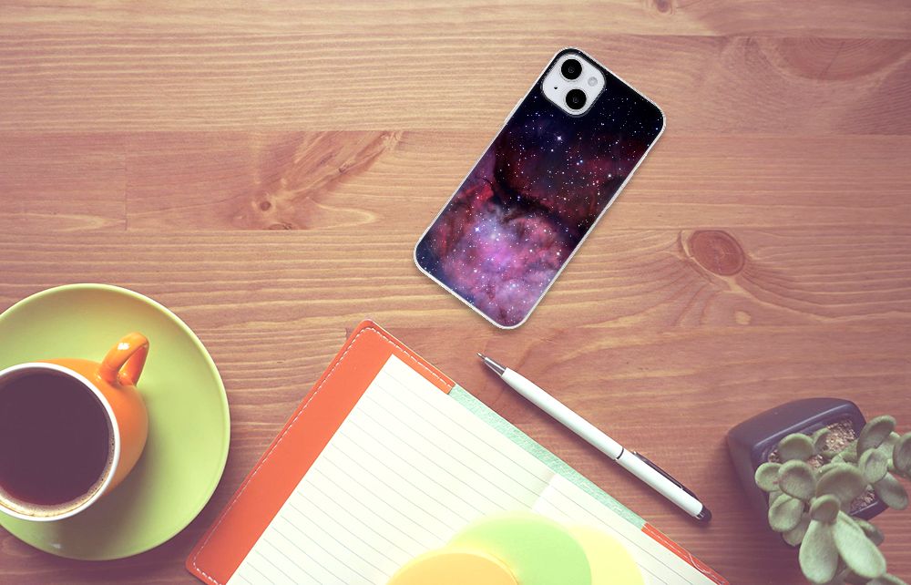 TPU Hoesje voor iPhone 15 Plus Galaxy met een prachtig ruimte design op een houten tafel.