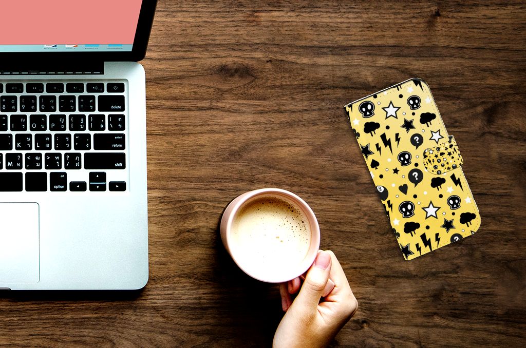 Telefoonhoesje met Naam iPhone 15 Pro Punk Geel op een tafel met laptop en koffie.