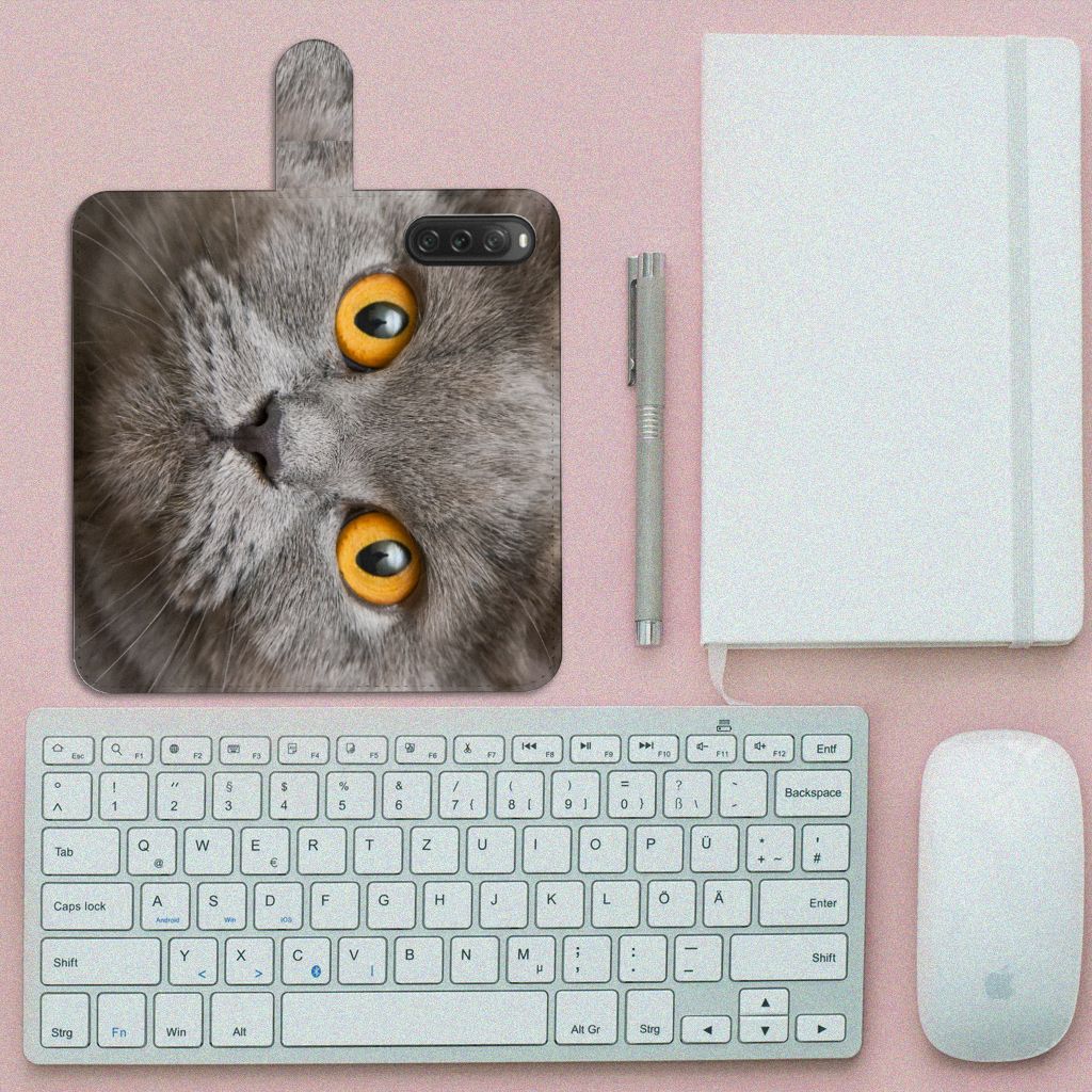 Telefoonhoesje met Pasjes Sony Xperia 10 V Britse Korthaar op een bureau naast een toetsenbord en notitieboek.