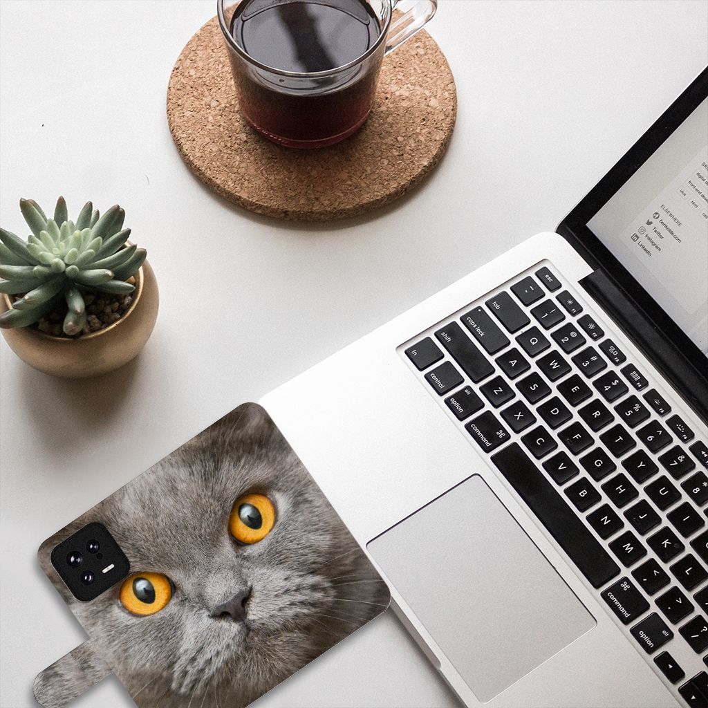 Telefoonhoesje met Pasjes Xiaomi 13 Britse Korthaar op een bureau met een laptop en een kopje koffie.