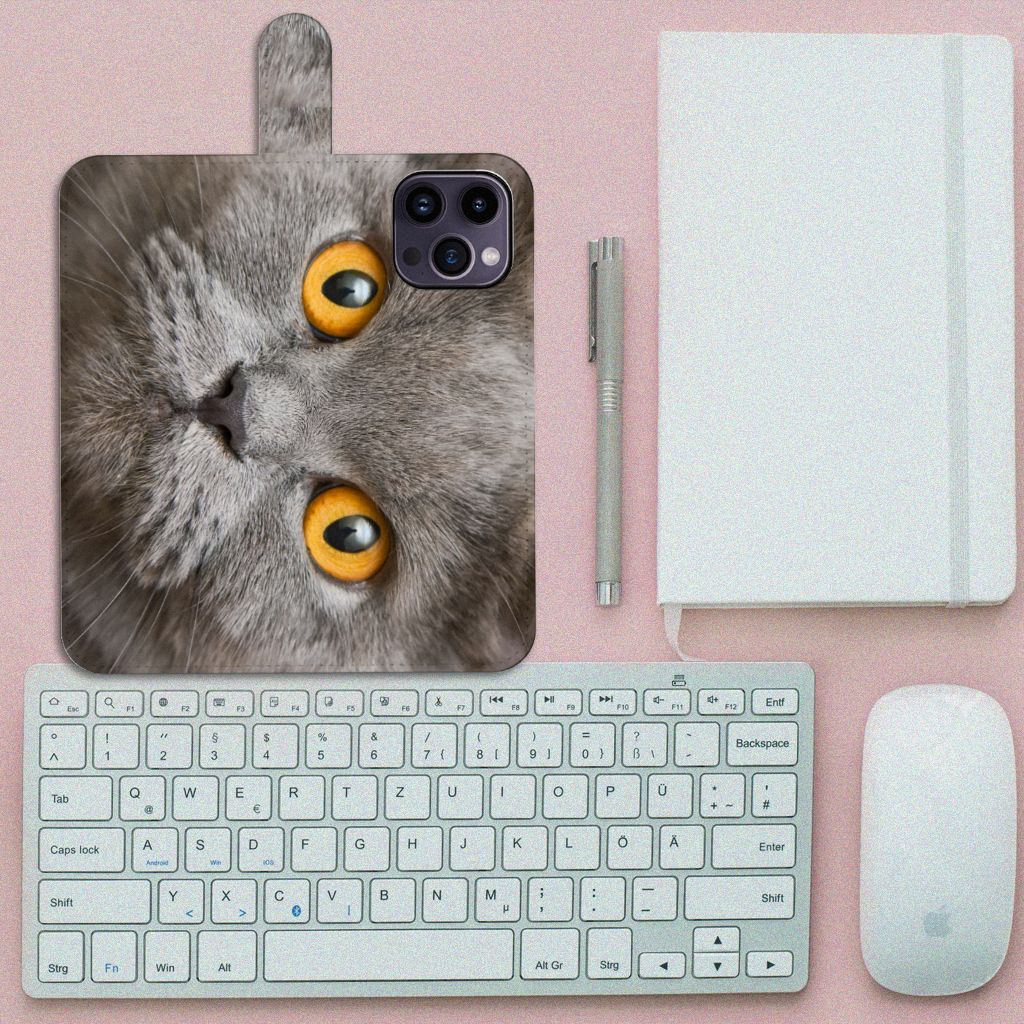 Telefoonhoesje met Pasjes iPhone 15 Pro Max Britse Korthaar met grijze kat en gele ogen op bureau met toetsenbord