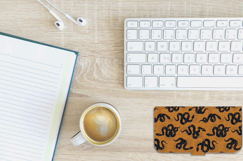 Telefoonhoesje met Pasjes voor iPhone 15 Plus Snakes ligt op een bureau met een notitieboek en een kopje koffie ☕.