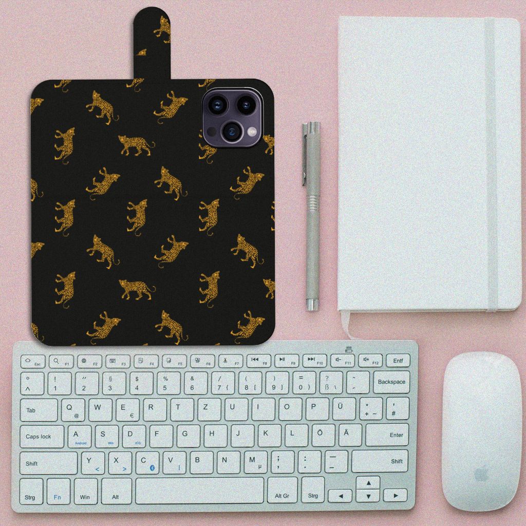 Telefoonhoesje met Pasjes voor iPhone 15 Pro Max Leopards met luipaardprint op bureau met toetsenbord en notitieboek.