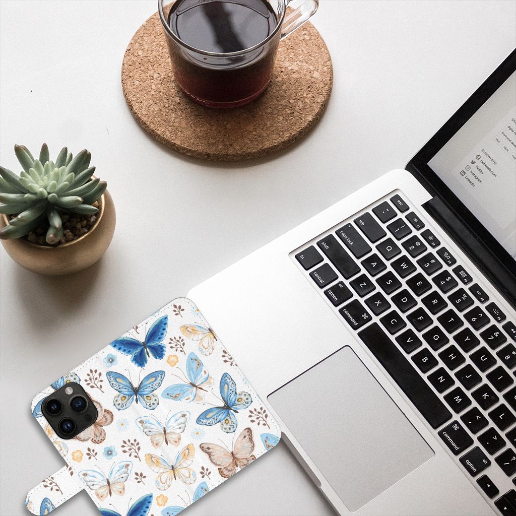 Telefoonhoesje met Pasjes voor iPhone 15 Pro Vlinder op een bureau met een laptop en een drankje.