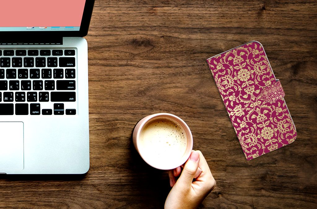 Wallet Case iPhone 15 Pro Max Barok Pink op een bureau met een laptop en een kopje koffie.