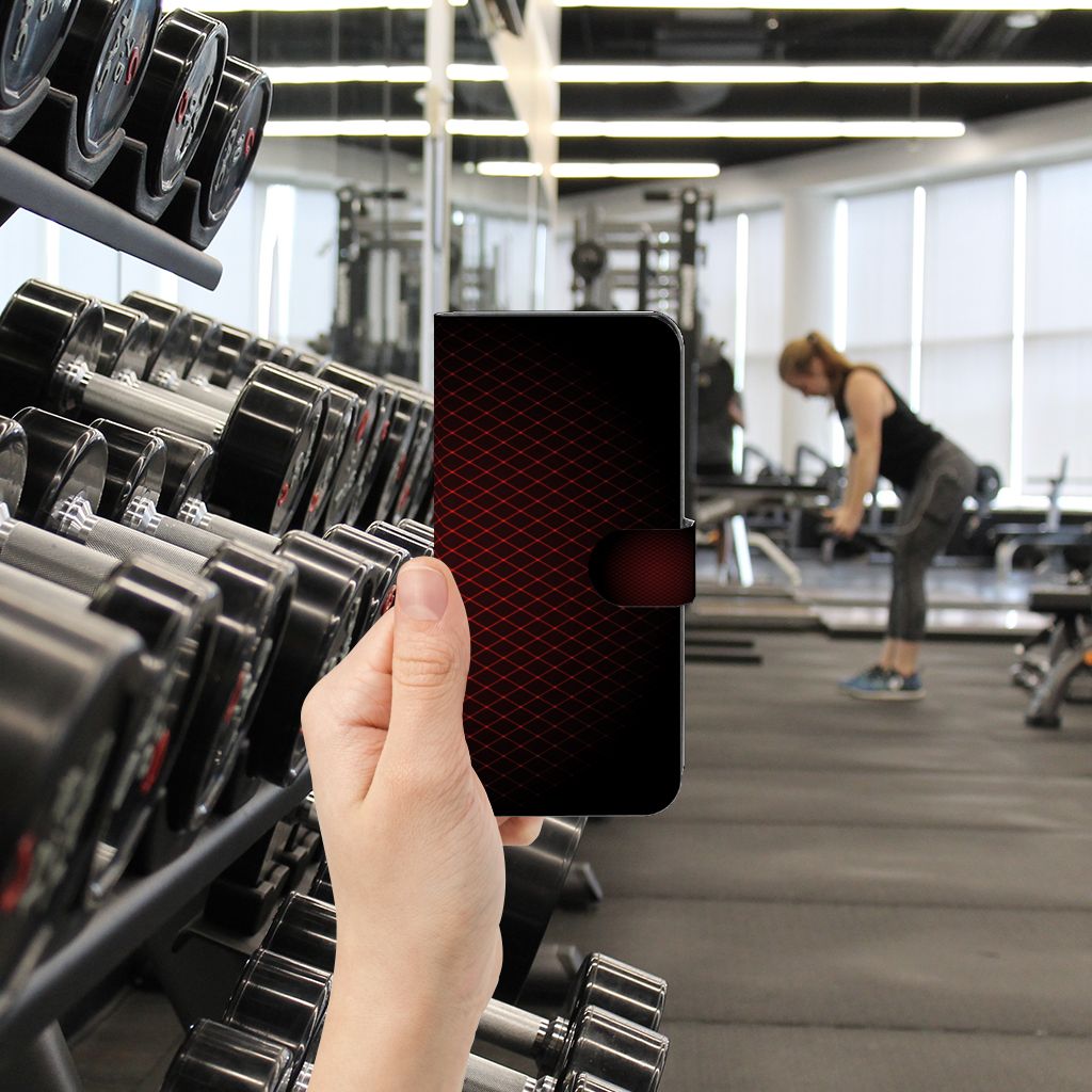 Xiaomi Poco F5 Telefoon Hoesje Geruit Rood in hand, met fitnessapparatuur op de achtergrond.