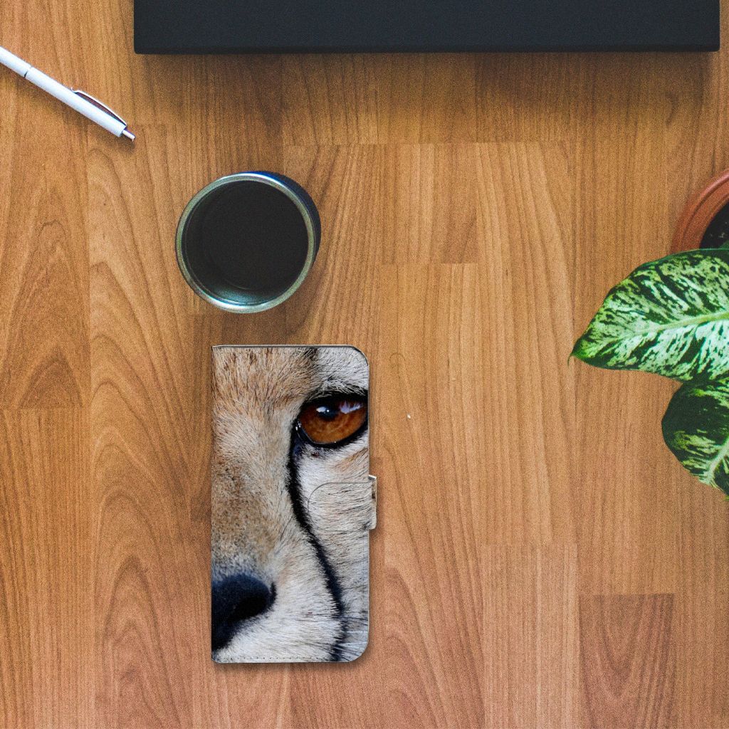 Xiaomi Redmi Note 12 Pro Plus Telefoonhoesje met Pasjes Cheetah op een houten tafel met een mok en plant ernaast.