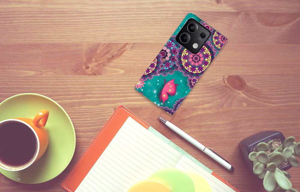 Xiaomi Redmi Note 13 5G Bookcase Cirkels en Vlinders op een bureau met een notitieboek en koffie, kleurrijk ontwerp