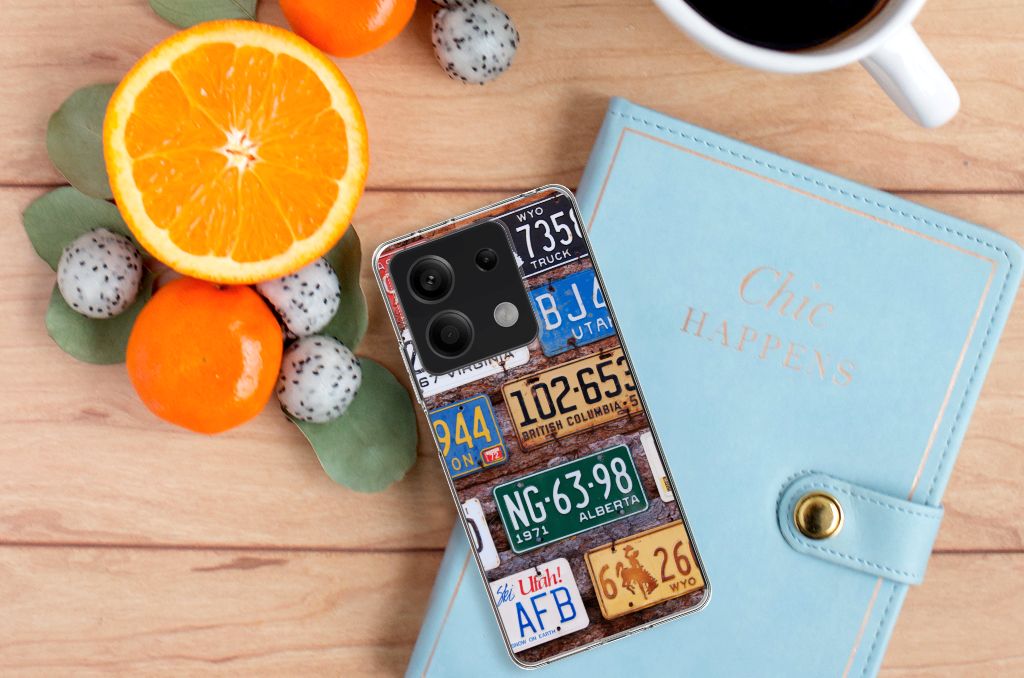 Xiaomi Redmi Note 13 5G Siliconen Hoesje met foto Kentekenplaten op een houten tafel met fruit en een notitieboek.