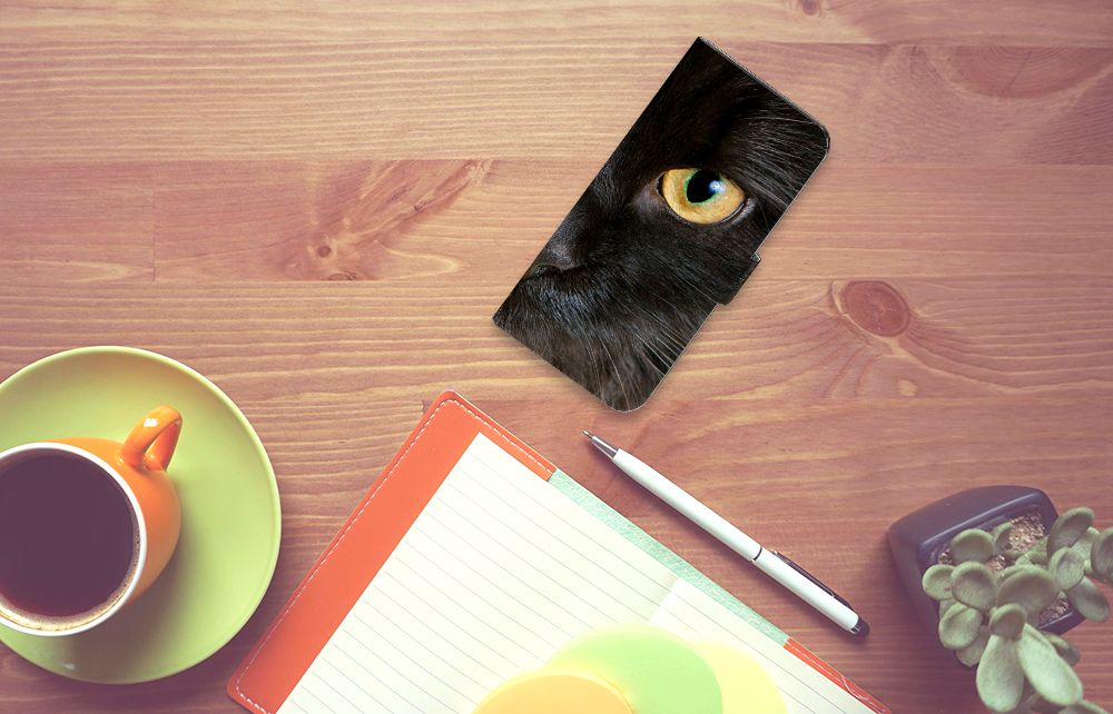 Xiaomi Redmi Note 13 5G Telefoonhoesje met Pasjes Zwarte Kat op een bureau met een kopje koffie en notitieboek.