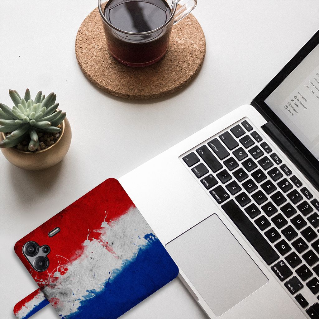 Xiaomi Redmi Note 13 Pro Plus Bookstyle Case Nederland op bureau met laptop en plant, Nederlandse vlag kunstzinnig ontwerp.