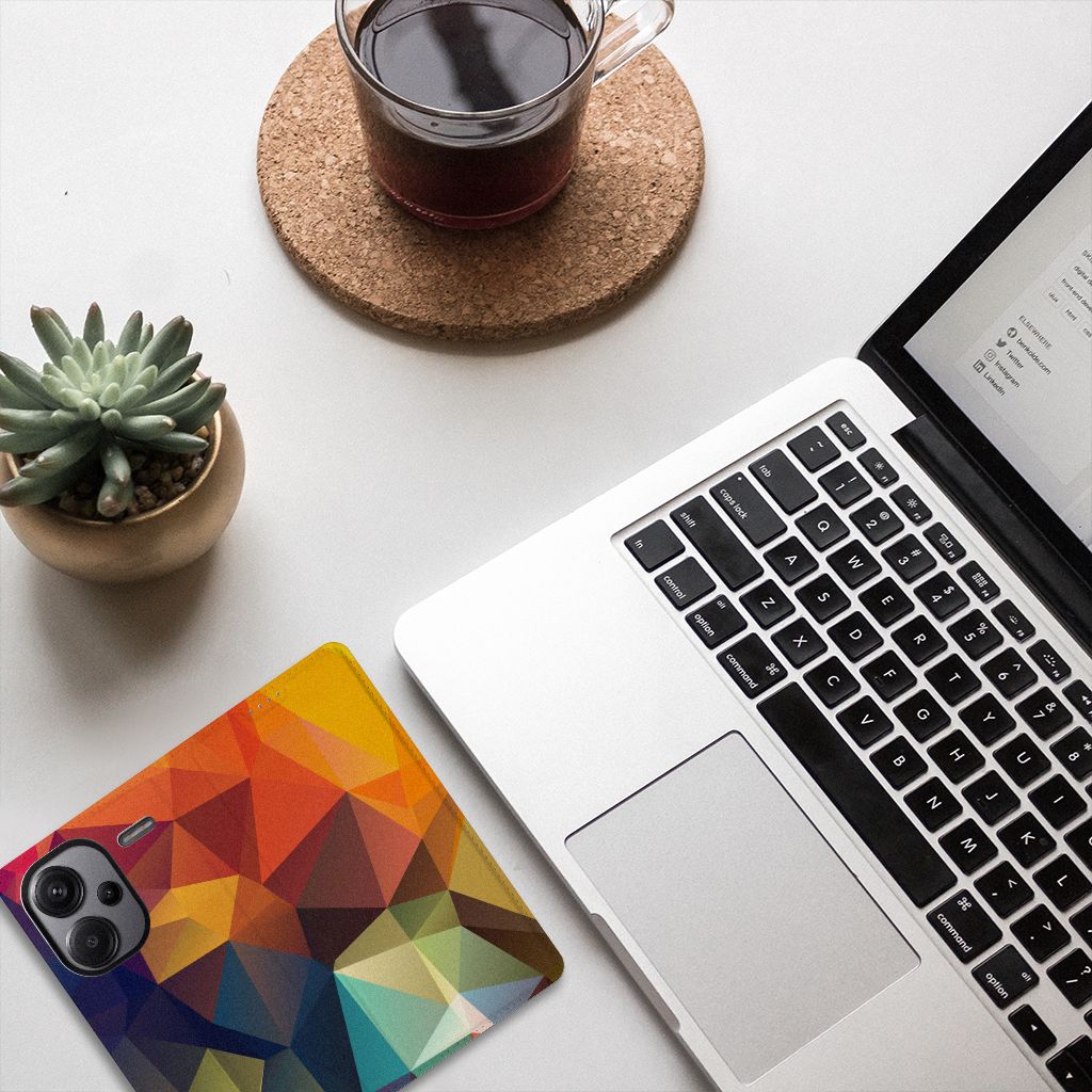 Xiaomi Redmi Note 13 Pro Plus Stand Case Polygon Color met kleurrijke geometrische patronen op een bureau met een laptop.
