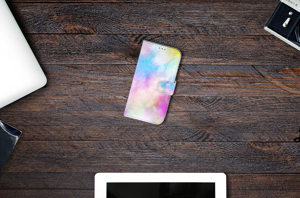 Hoesje iPhone 14 Pro Watercolor Light op een houten tafel met modern bureauaccessoires.