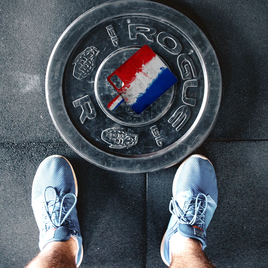 Persoon met blauwe schoenen staat boven een gewichtsplaat met een artistieke Nederlandse vlag, perfect voor sportliefhebbers.