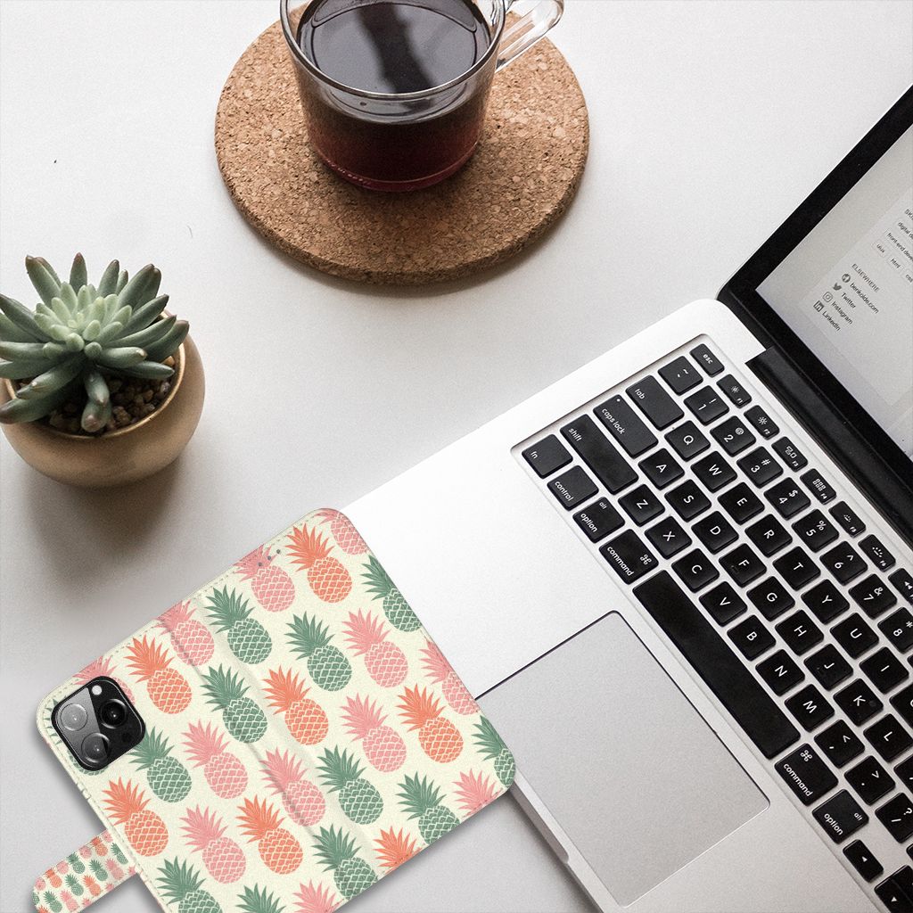iPhone 13 Pro Max Book Cover Ananas met kleurrijke ananassen op een bureau met laptop en koffie 🥤.