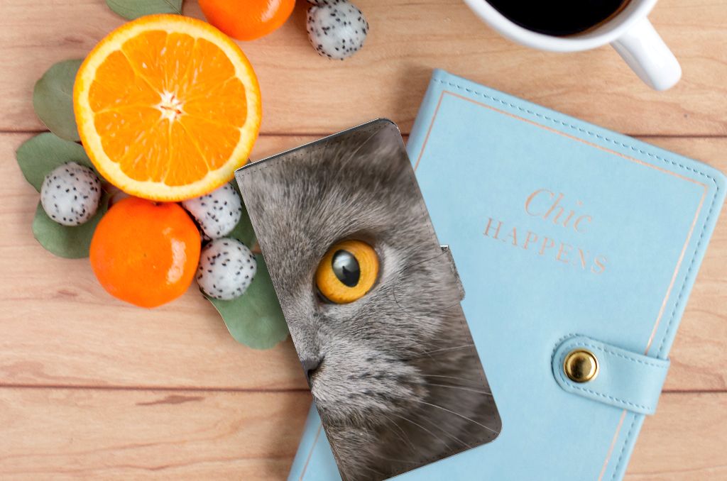 Telefoonhoesje met Pasjes Samsung Galaxy S24 Ultra Britse Korthaar naast een sinaasappel en een notitieboekje.