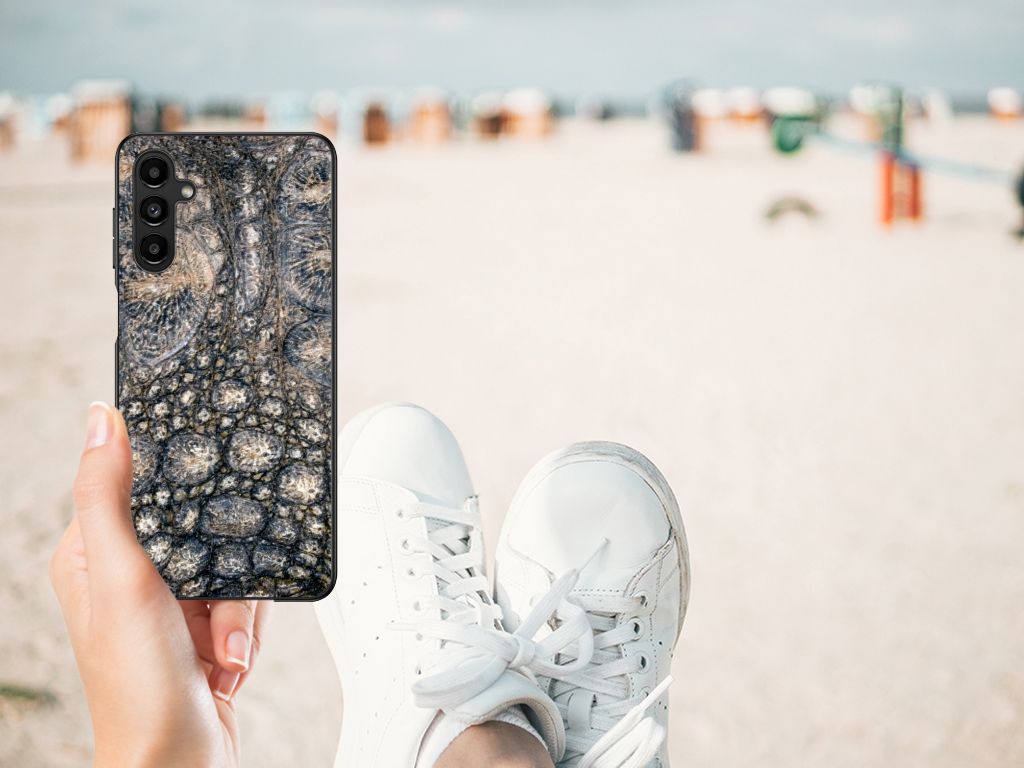 Samsung Galaxy A14 5G Dierenprint Telefoonhoesje Krokodillenprint in hand, casual stijl met sneakers op strand.