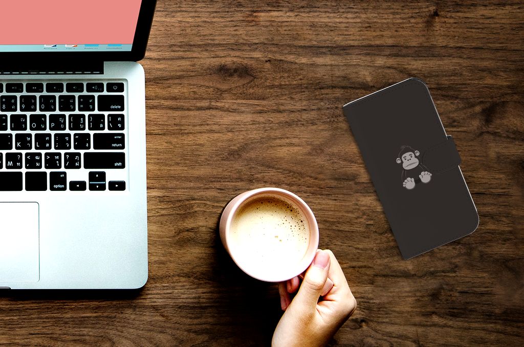 Close-up van iPhone 15 Pro Leuk Hoesje Gorilla op bureau met laptop en koffie. 🍵