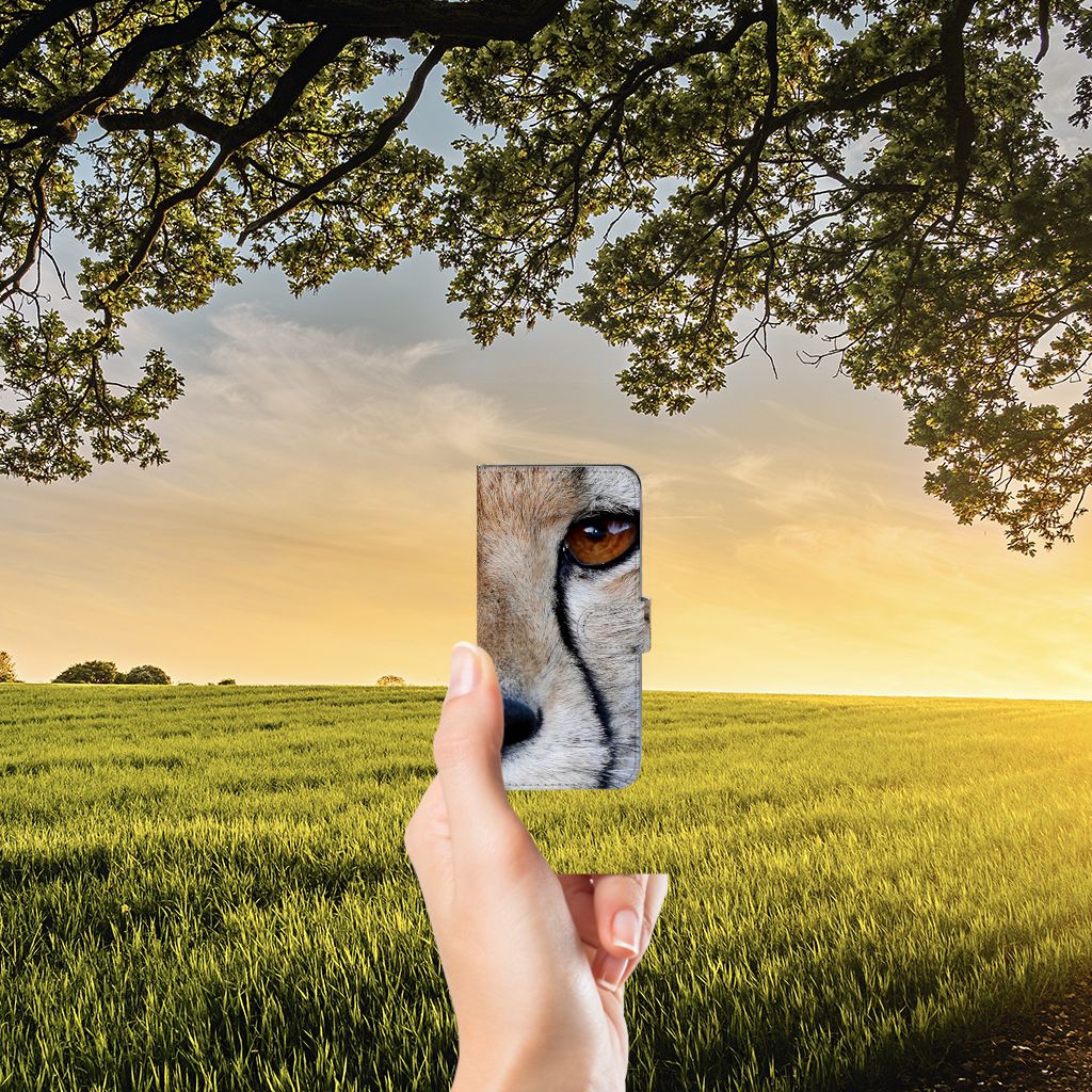 Samsung Galaxy A22 4G | M22 Telefoonhoesje met Pasjes Cheetah in een hand met een landschap op de achtergrond.