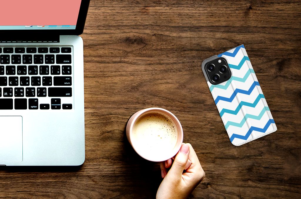 iPhone 13 Pro Hoesje met Magneet Zigzag Blauw naast een kop koffie op een bureau