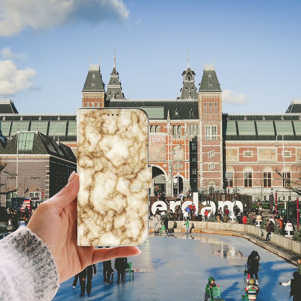 iPhone 13 Pro Max Bookcase Marmer Goud in hand voor het Rijksmuseum in Amsterdam.