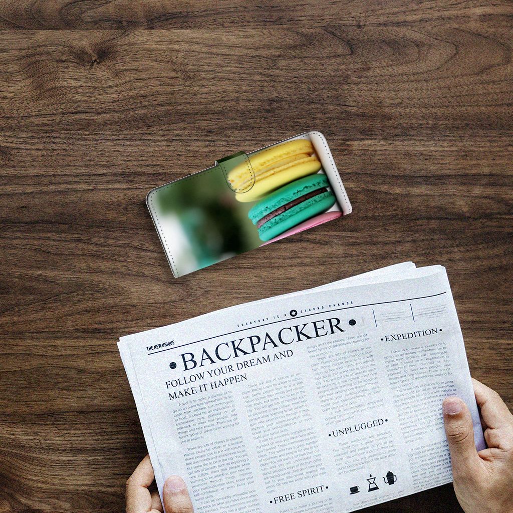 Samsung Galaxy A14 4G Book Cover Macarons on a wooden table with a newspaper.