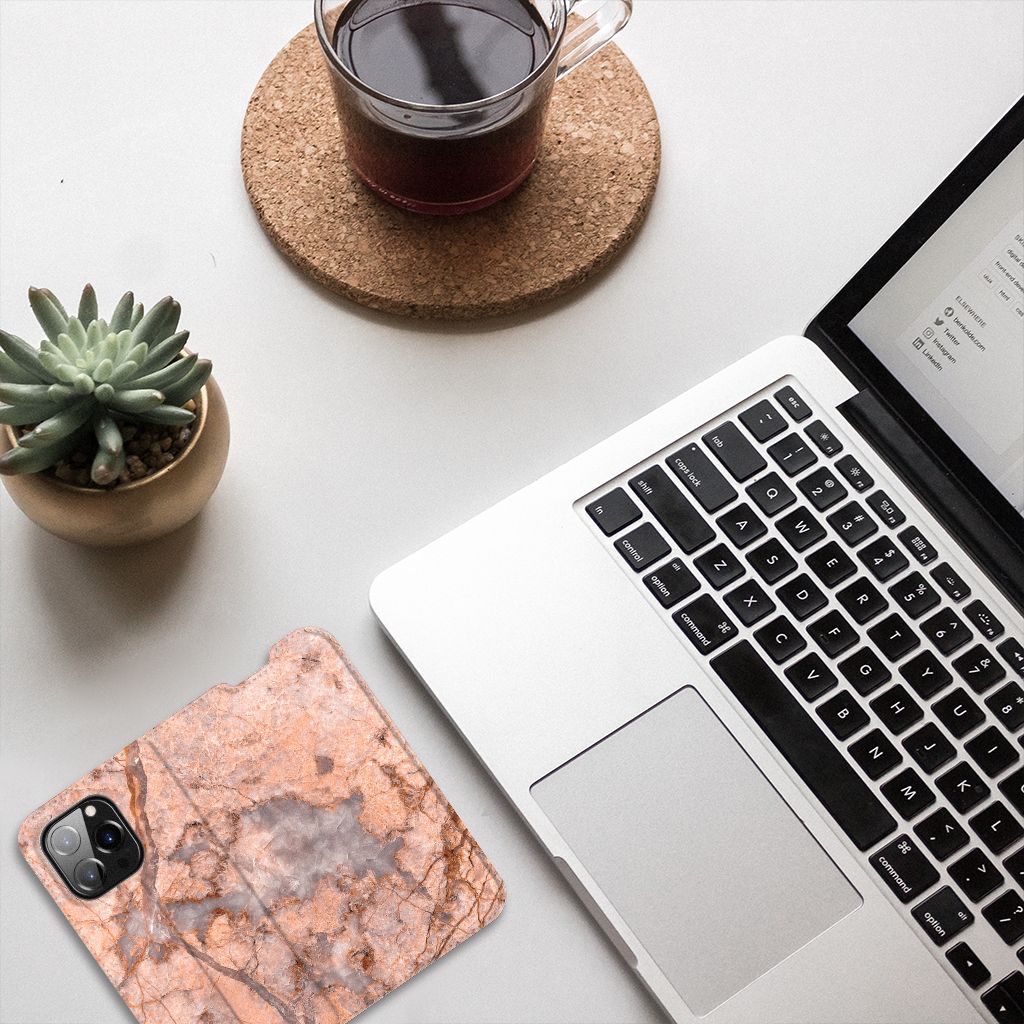 iPhone 14 Pro Standcase Marmer Oranje op een bureau met een laptop en een plant 🌱.