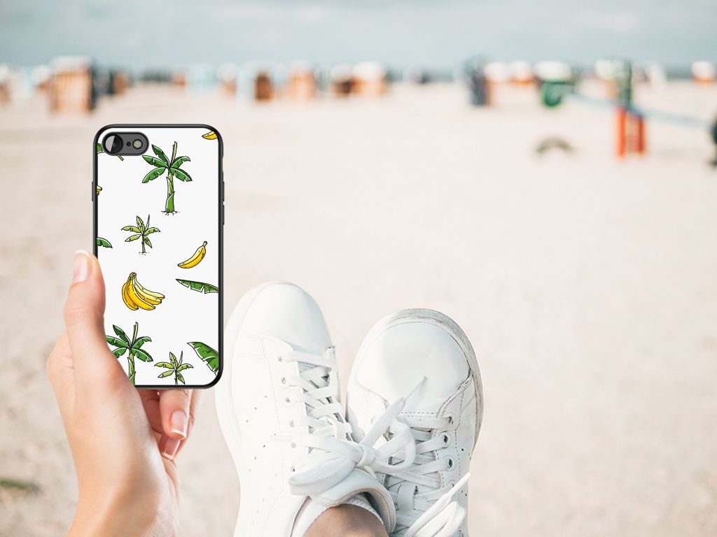 Hand holding iPhone SE 2022 | SE 2020 | 7/8 Bloemen Hoesje Banana Tree on the beach, showcasing tropical design.