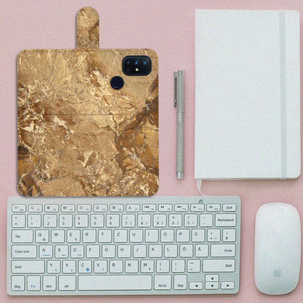 OnePlus Nord N10 Bookcase Marmer Creme op een bureau met toetsenbord en notitieboek.