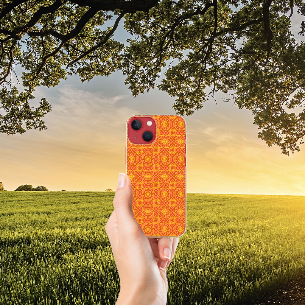 Apple iPhone 13 TPU bumper Batik Oranje in een hand met een prachtig zonsonderganglandschap op de achtergrond.
