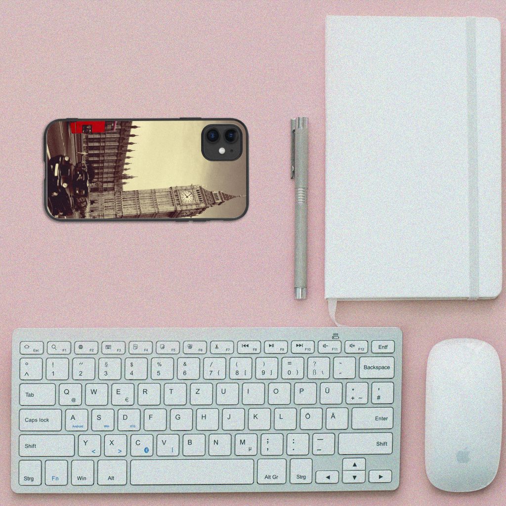 iPhone 11 TPU Backcover Londen met reizen print en zwart rand, geplaatst op een bureau met toetsenbord en notitieboek.