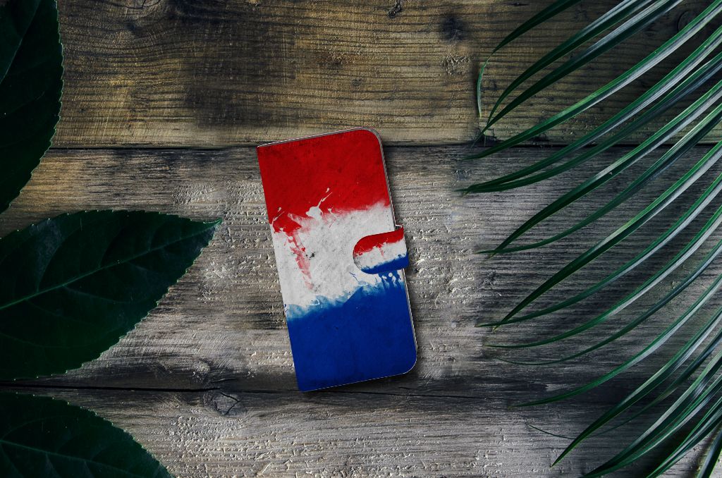 Nokia C12 Bookstyle Case Nederland met artistiek design van de Nederlandse vlag op een houten tafel met bladeren.