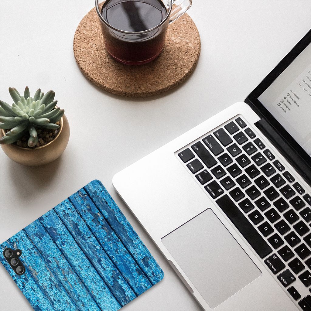 Samsung Galaxy A14 5G Book Wallet Case Wood Blue displayed on a desk with a laptop and coffee.