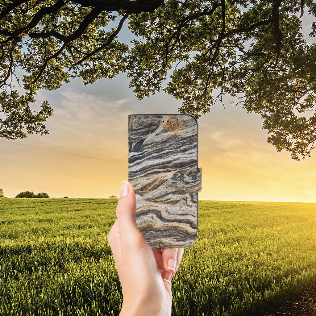 Apple iPhone 13 Bookcase Steen in hand met natuurlijk landschap en zonsondergang op achtergrond